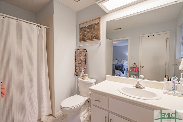 bathroom with toilet, a skylight, tile patterned flooring, a shower with shower curtain, and vanity