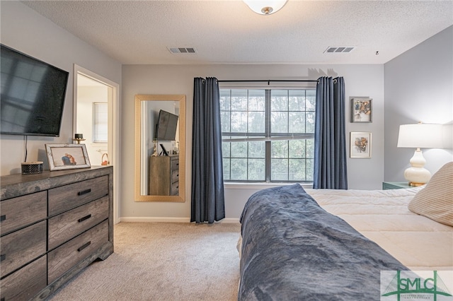 bedroom featuring light colored carpet and a textured ceiling