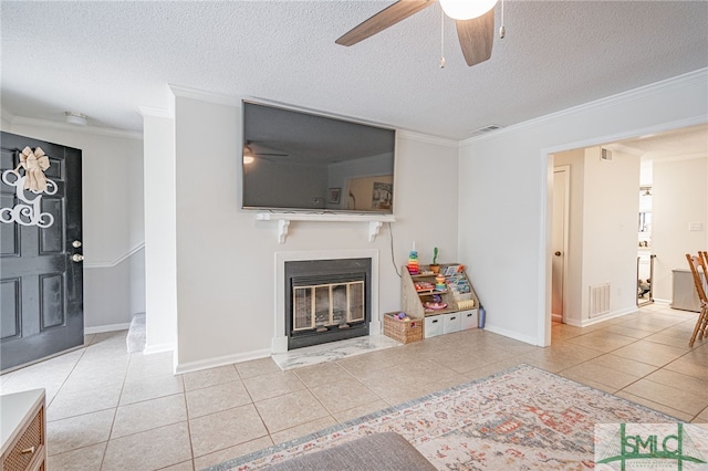 living room with ceiling fan, ornamental molding, a textured ceiling, and light tile patterned flooring