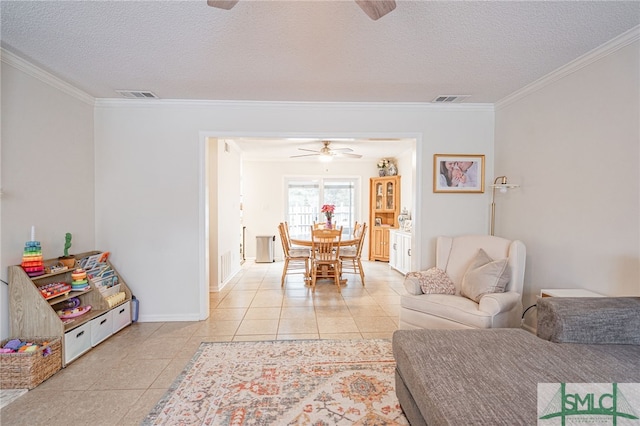 living room with ceiling fan, ornamental molding, light tile patterned floors, and a textured ceiling