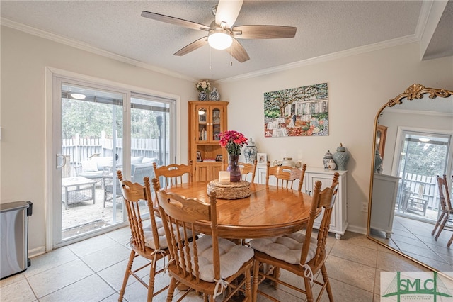 tiled dining space featuring ceiling fan, a textured ceiling, and crown molding