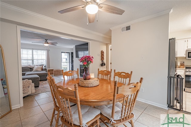 dining space featuring crown molding, a textured ceiling, and light tile patterned floors