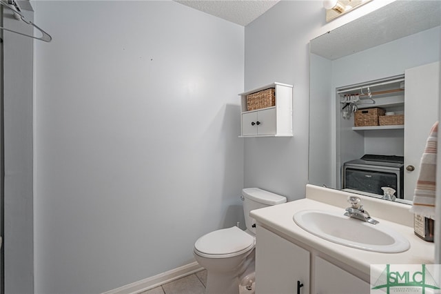 bathroom with toilet, a textured ceiling, tile patterned flooring, and vanity