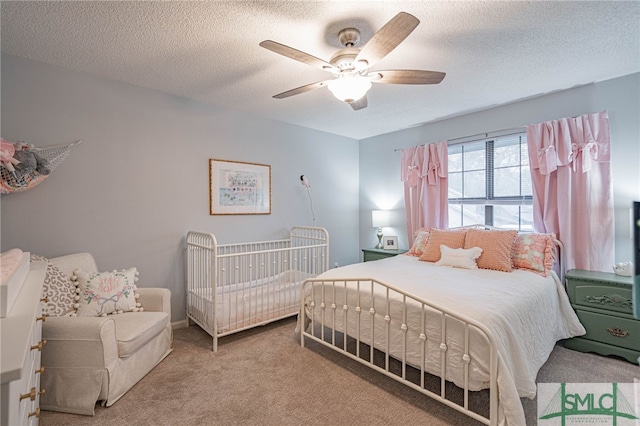 bedroom featuring ceiling fan, a textured ceiling, and carpet floors