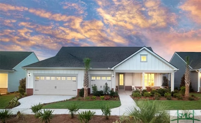 view of front of property featuring covered porch, a yard, and a garage