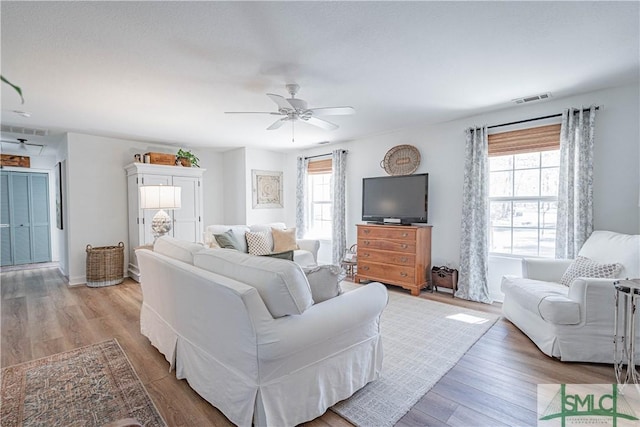 living room featuring ceiling fan, a healthy amount of sunlight, and wood-type flooring