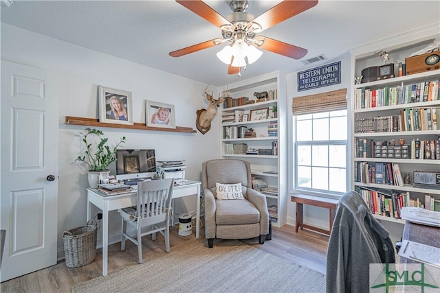 office with light hardwood / wood-style flooring and ceiling fan