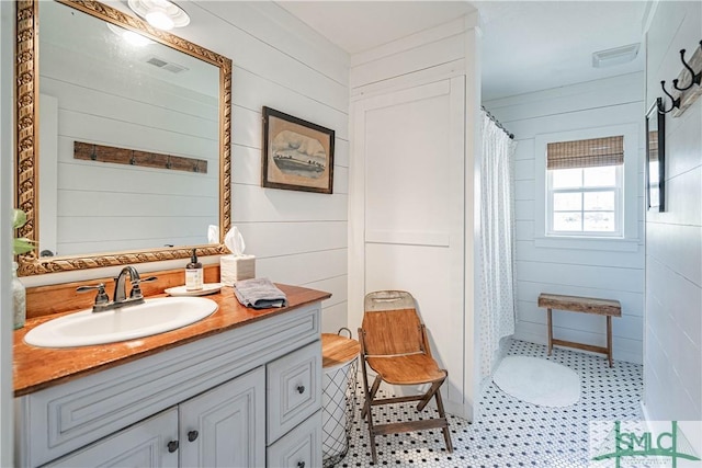 bathroom featuring wood walls, curtained shower, and vanity