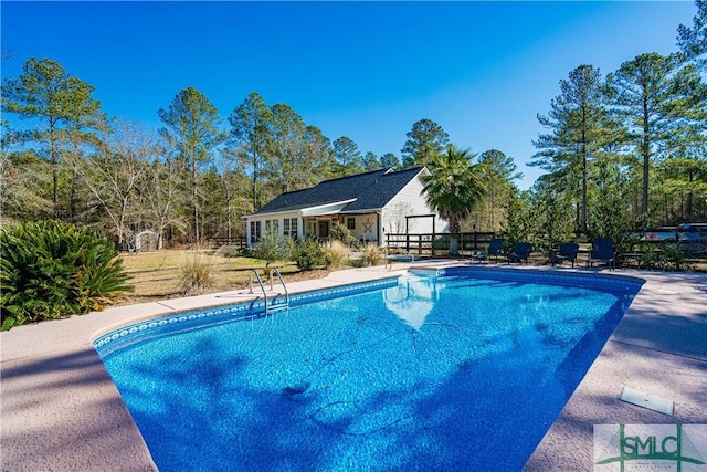 view of swimming pool featuring an outbuilding