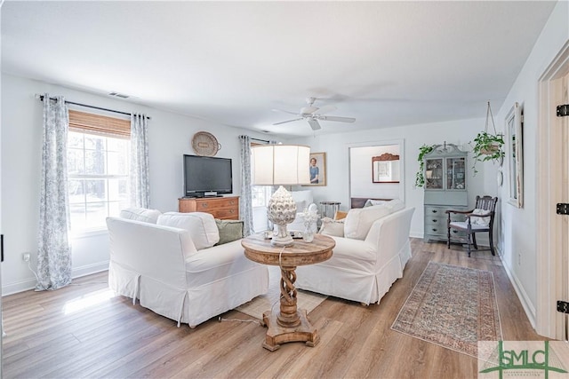 living room featuring light wood-type flooring and ceiling fan