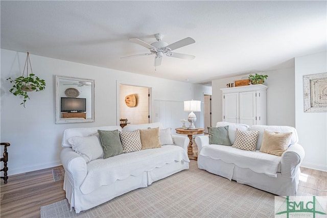 living room featuring light wood-type flooring and ceiling fan