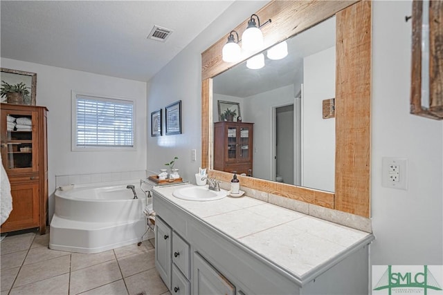 bathroom with a bathing tub, tile patterned floors, and vanity