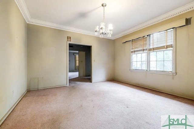 carpeted spare room with ornamental molding and an inviting chandelier