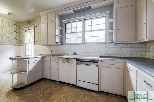 kitchen with white dishwasher, decorative backsplash, and white cabinets