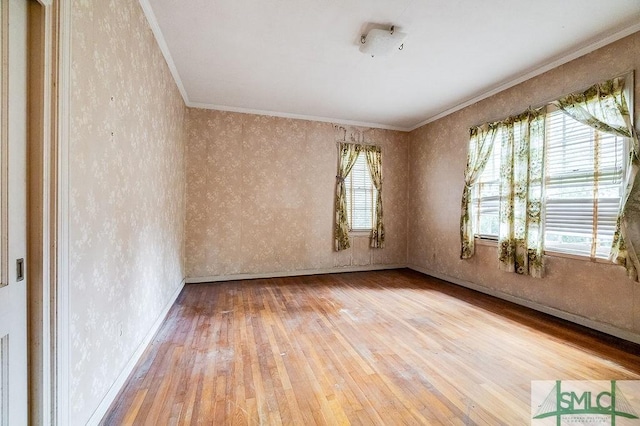 empty room featuring crown molding and wood-type flooring