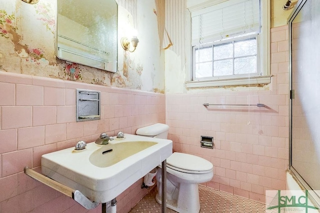 bathroom with tile patterned floors, sink, tile walls, and toilet