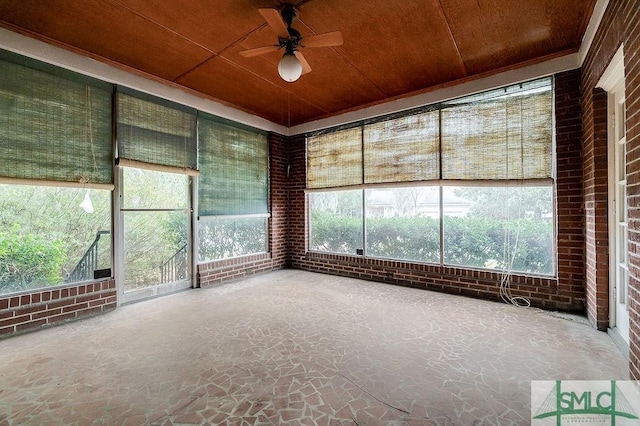 unfurnished sunroom featuring ceiling fan and wood ceiling