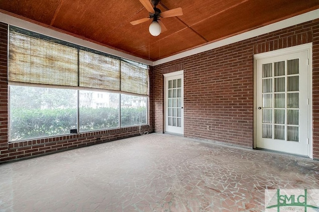 unfurnished sunroom featuring wood ceiling and ceiling fan