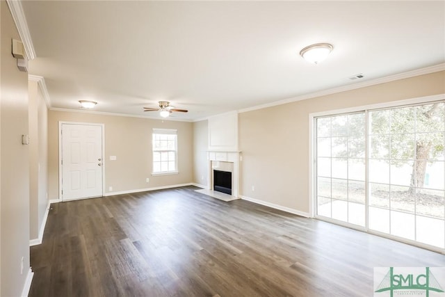 unfurnished living room featuring dark wood-style floors, a fireplace, baseboards, and crown molding