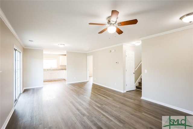 unfurnished living room featuring stairway, baseboards, and wood finished floors