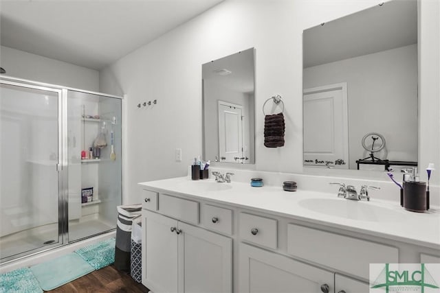 bathroom with hardwood / wood-style flooring, vanity, and an enclosed shower