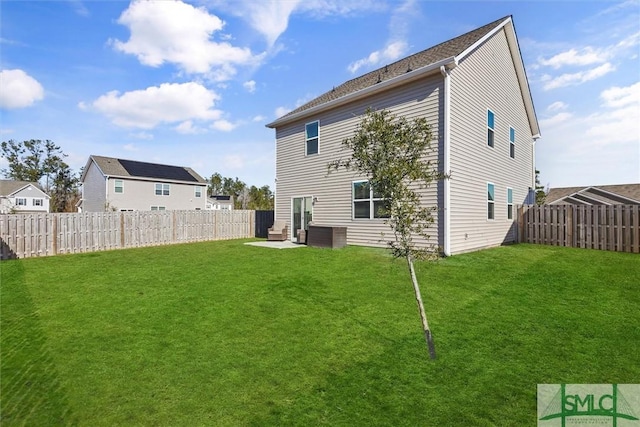 rear view of house featuring a lawn and a patio