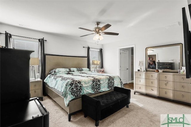 carpeted bedroom featuring multiple windows and ceiling fan