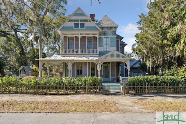 victorian house featuring a balcony and a porch