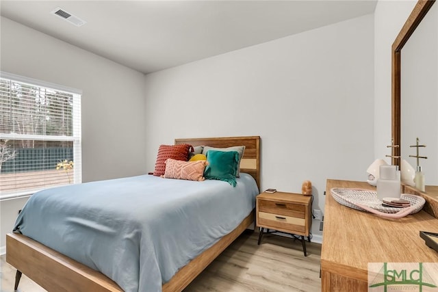 bedroom featuring multiple windows and light wood-type flooring