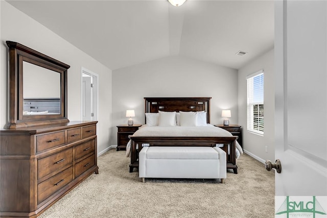 bedroom with light colored carpet and vaulted ceiling