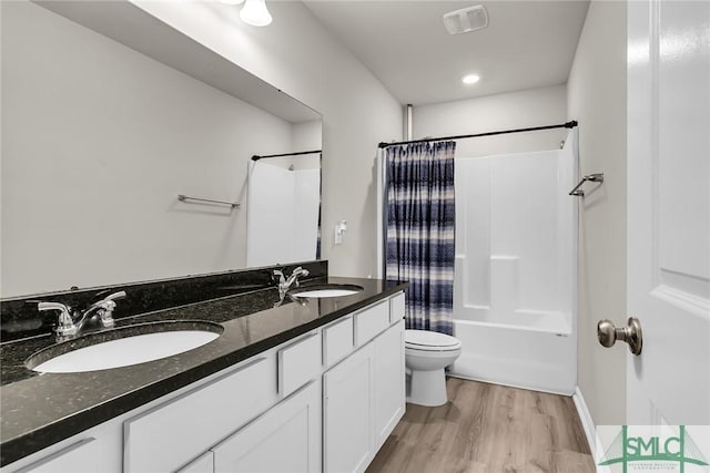 full bathroom with shower / bath combo with shower curtain, hardwood / wood-style floors, toilet, and vanity