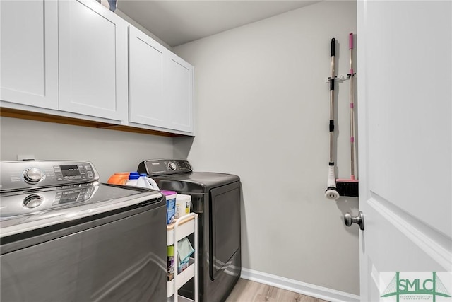 laundry area with cabinets, independent washer and dryer, and light wood-type flooring