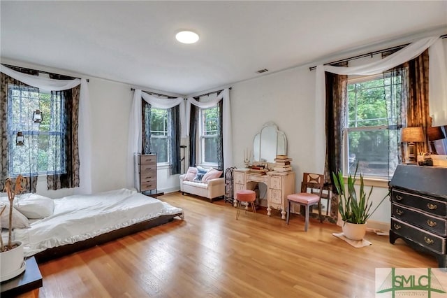 bedroom featuring wood-type flooring and multiple windows