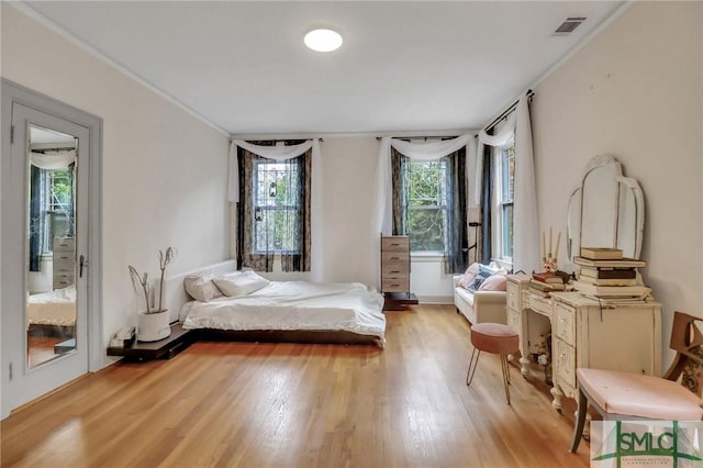 bedroom with light hardwood / wood-style floors and ornamental molding