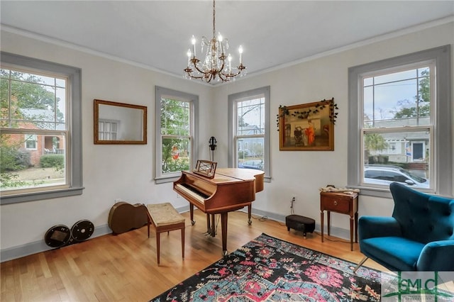 miscellaneous room featuring hardwood / wood-style floors, an inviting chandelier, and ornamental molding