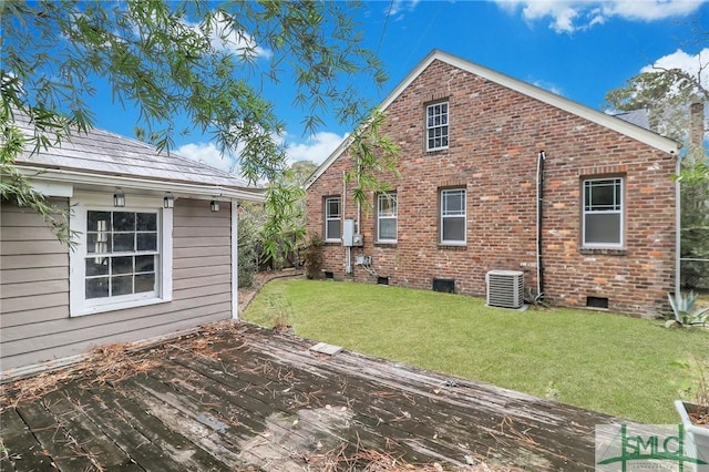 exterior space featuring a wooden deck, a yard, and central AC