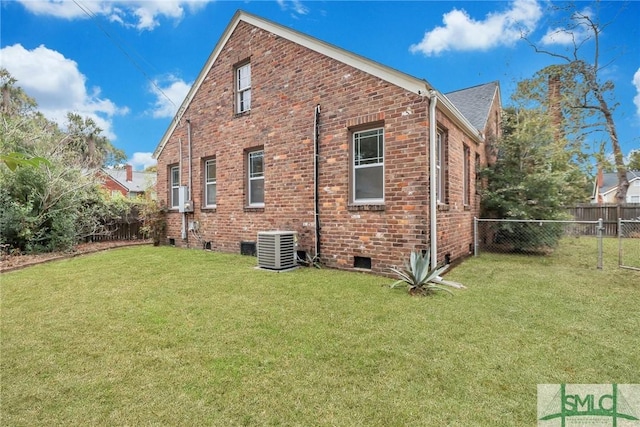 rear view of house featuring cooling unit and a lawn