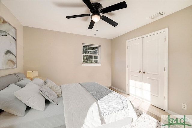 bedroom featuring ceiling fan, a closet, and light wood-type flooring