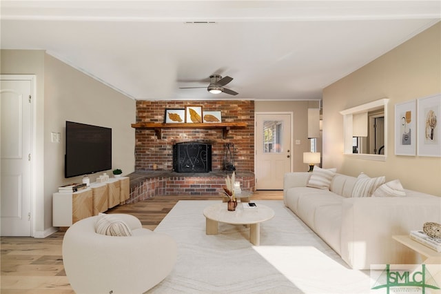 living room with a fireplace, light hardwood / wood-style flooring, and ceiling fan