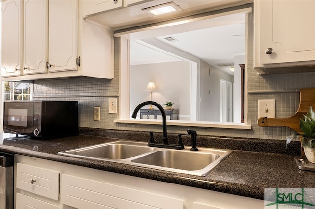 kitchen with sink, white cabinetry, and backsplash