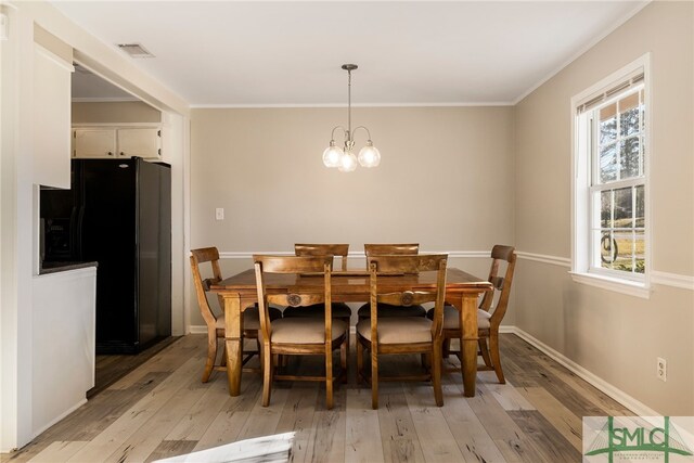 dining space featuring a wealth of natural light, a chandelier, and light wood-type flooring