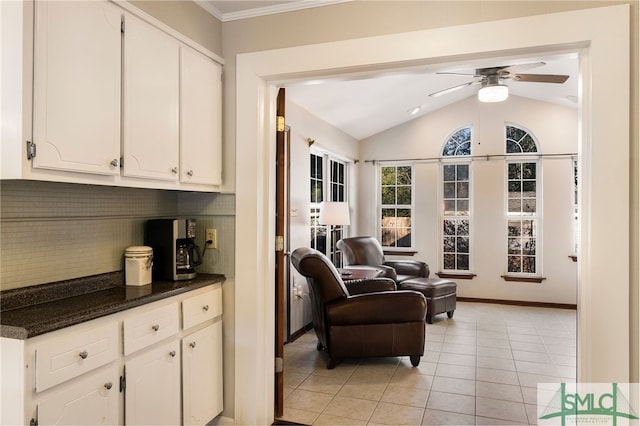 sitting room featuring ceiling fan, light tile patterned floors, and lofted ceiling