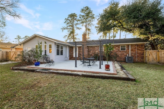 back of house with central AC unit, a patio area, and a lawn