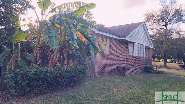 view of side of home with a yard