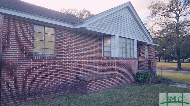 property exterior at dusk with a lawn