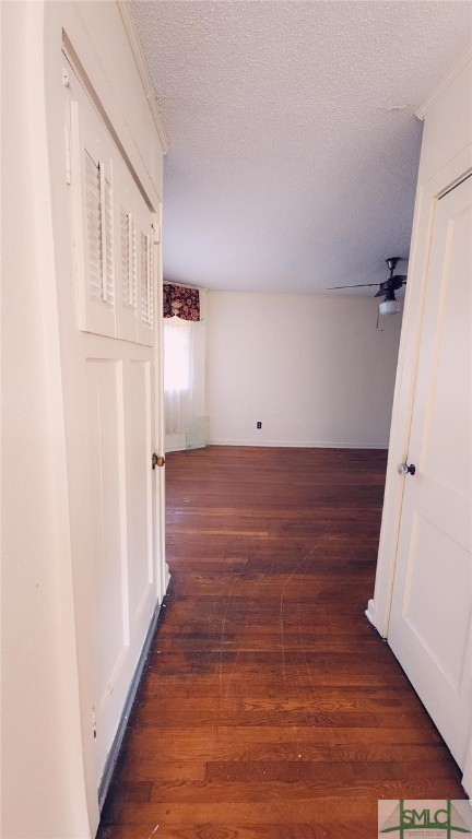 hall featuring a textured ceiling and dark hardwood / wood-style flooring