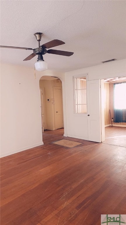 unfurnished room with hardwood / wood-style flooring, ceiling fan, and a textured ceiling