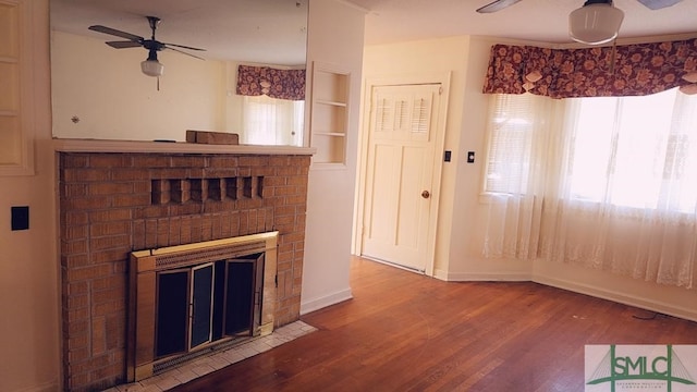 unfurnished living room featuring built in features, ceiling fan, hardwood / wood-style floors, and a fireplace