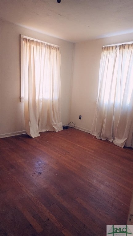 unfurnished room with dark hardwood / wood-style flooring