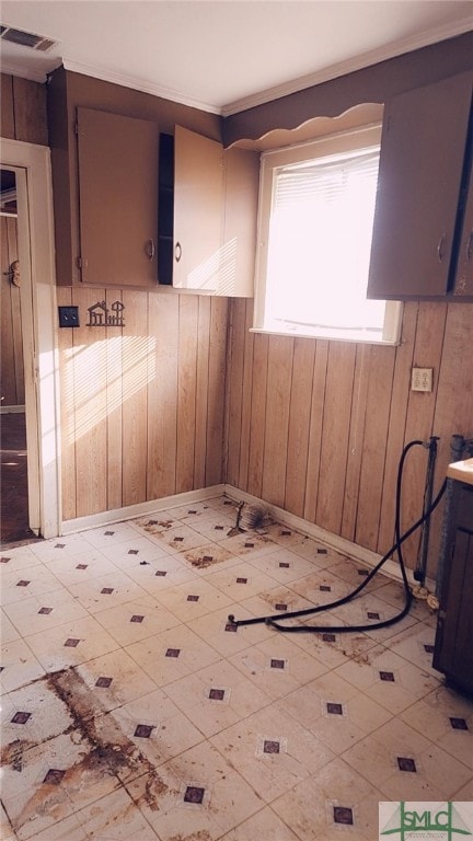 empty room with crown molding and wooden walls